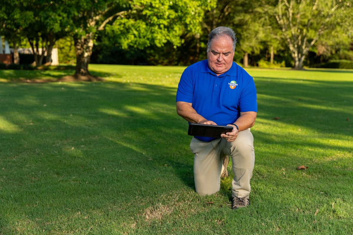 lawn care account manager measuring lawn tablet